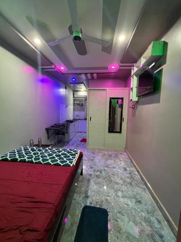 a room with a bed in a room with purple lights at Dusilu Homestay in Bhadrak