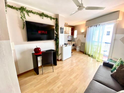 un salon avec un canapé et une télévision sur un mur dans l'établissement Le Nouveau Port By SCLS Locations, à Cannes