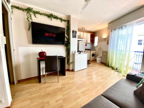 een woonkamer met een tafel en een tv aan de muur bij Le Nouveau Port By SCLS Locations in Cannes