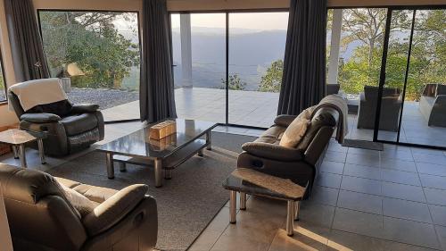 a living room with couches and chairs and a table at Oribi Gorge Villa in Glendale
