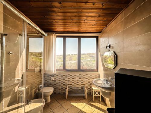 baño con lavabo y aseo y ventana en B&B Il Leccio, en Alberobello