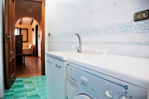 a kitchen with a sink and a laundry room at Appartamento in villa al mare in Siracusa