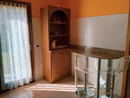 a kitchen with a counter and a table and a window at Doris' home in Pisogne