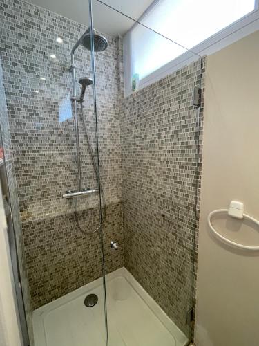 baño con ducha y puerta de cristal en Appartement Les Moulins, en Saint-Tropez