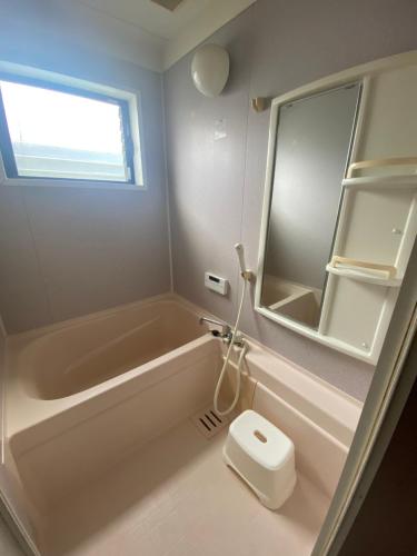a bathroom with a tub and a toilet and a mirror at 澄の宿 京都伏见稻荷別邸 京阪电车伏见稻荷站徒步1分钟 jr电车稻荷站徒步4分钟 in Kyoto
