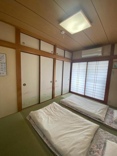 a room with two beds in it with windows at 澄の宿 京都伏见稻荷別邸 京阪电车伏见稻荷站徒步1分钟 jr电车稻荷站徒步4分钟 in Kyoto