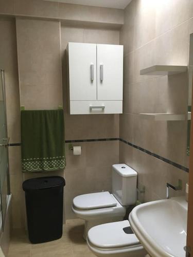 een kleine badkamer met 2 toiletten en een wastafel bij Apartamento nuevo en pleno centro. in Carboneras