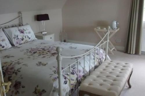een slaapkamer met een wit bed en een stoel bij 7 Burnside House in Kilmorack