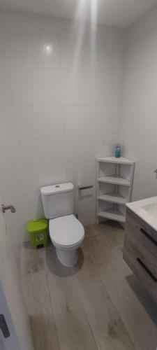 a white bathroom with a toilet and a sink at Casita Emma in Playa Blanca
