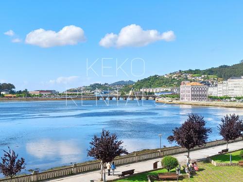 a view of a river with people walking on a sidewalk at Ría de Viveiro 2 in Viveiro