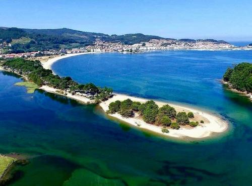 an island in the middle of a body of water at VILLA RAICES. Agradable casa con piscina in Baiona