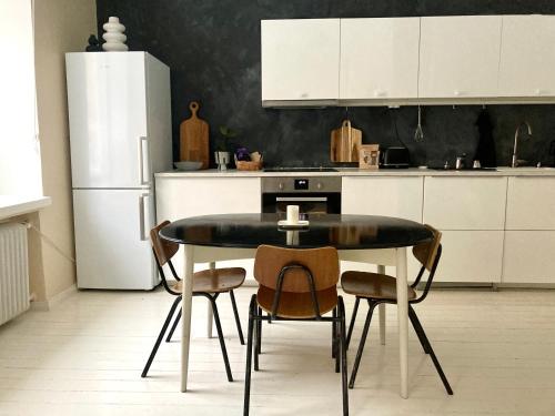赫爾辛基的住宿－Spacious (44 sqm) bohemian studio in trendy Kallio，厨房配有桌椅和冰箱。