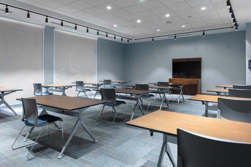 a conference room with tables and chairs and a screen at Aloft Orlando Lake Buena Vista in Orlando