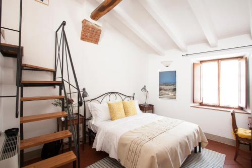 ein weißes Schlafzimmer mit einem Bett und einer Treppe in der Unterkunft B&B Borgolecchi , Lecchi in Chianti in San Sano