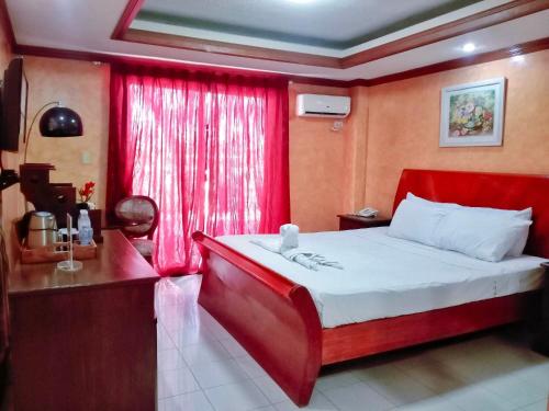 a bedroom with a red bed and a red window at PALM TREE RESORT AND RESTAURANT in Olongapo