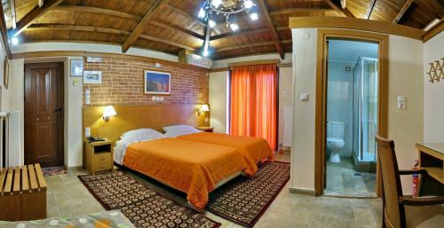 a bedroom with a large bed and a bathroom at TARLAS ROOMS in Mytilene