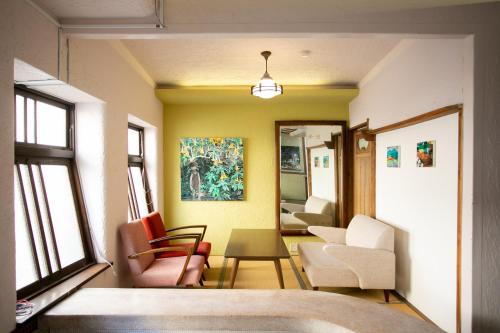 sala de estar con sillas y mesa en Mojiko Guesthouse PORTO en Kitakyushu