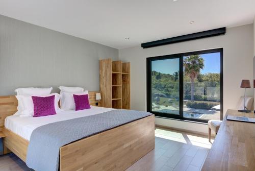 a bedroom with a large bed with purple pillows at Luxury Zen in Châteauneuf