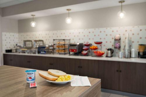 a table with a plate of food and a bowl of eggs at Ramada by Wyndham Allentown Bethlehem in Allentown