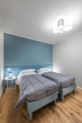 Habitación con 2 camas, paredes azules y suelo de madera. en Le Dimore di Giò, en Ortona