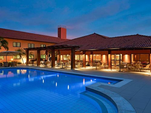 a large swimming pool in front of a building at Novotel Campo Grande in Campo Grande