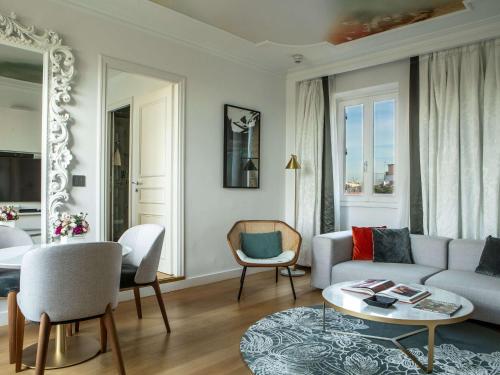 ein Wohnzimmer mit einem Sofa und einem Tisch in der Unterkunft Sofitel Roma Villa Borghese in Rom
