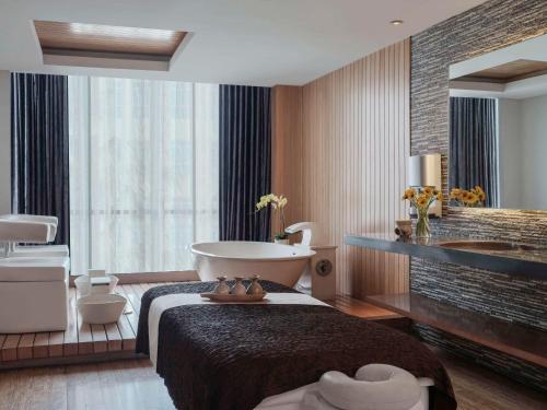 بولمان جاكارتا سنترال بارك في جاكرتا: غرفة في الفندق مع حوض استحمام وحمام