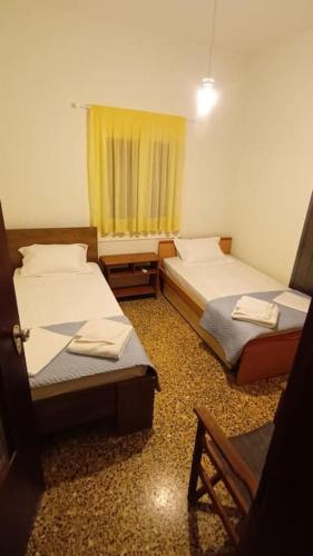 a room with two beds and a chair and a window at Blackbeard's House - Kastri Crete in Kastrí