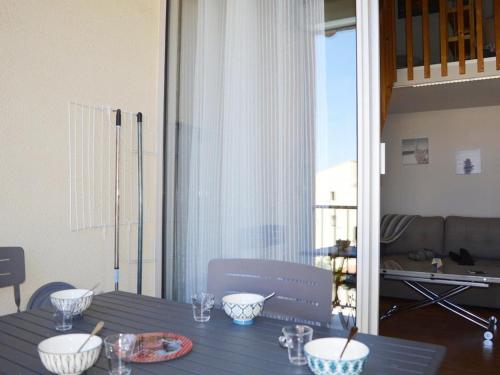 - une table avec des bols dans le salon dans l'établissement Appartement 2 pièces avec piscine et parking à Narbonne Plage - FR-1-229B-73, à Narbonne