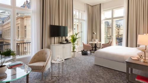 a hotel room with a bed and a desk and chairs at Hôtel du Louvre, in The Unbound Collection by Hyatt in Paris