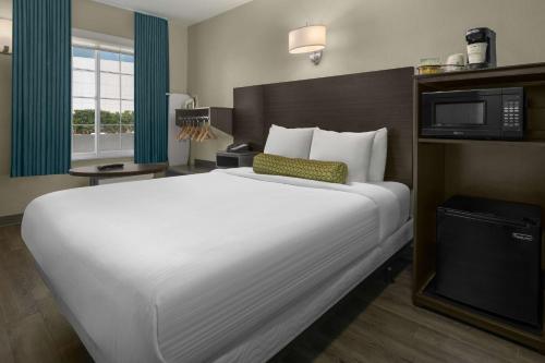 a hotel room with a large bed and a television at SureStay Hotel by Best Western San Diego Pacific Beach in San Diego