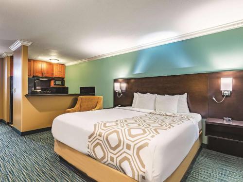 a hotel room with a large bed and a kitchen at La Quinta by Wyndham San Francisco Airport West Millbrae FREE AIRPORT SHUTTLE in Millbrae