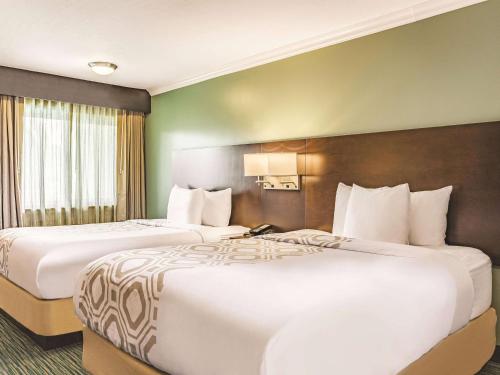 two beds in a hotel room with two at La Quinta by Wyndham San Francisco Airport West Millbrae FREE AIRPORT SHUTTLE in Millbrae