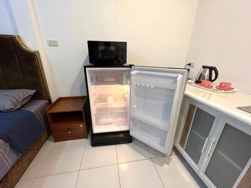 a refrigerator with its door open in a room at Rose Garden Guest House Soi 88 Hua Hin in Hua Hin