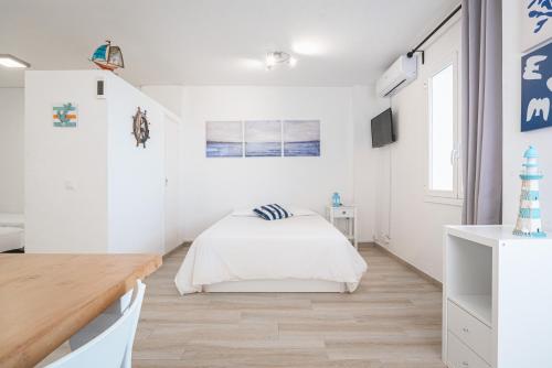- une chambre blanche avec un lit et un bureau dans l'établissement Spondylus Apartment, à Empuriabrava