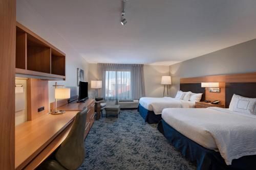 Cette chambre comprend deux lits et une télévision. dans l'établissement TownePlace Suites by Marriott Monroe, à Monroe