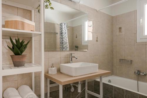bagno con lavandino, vasca e specchio di Theseus Seafront House a Sami