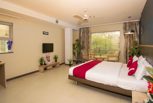 a hotel room with a bed and a tv at Octave Koregaon Park in Pune