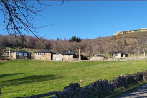 a field with houses and a hill in the background at O Busto Aldea Rural 