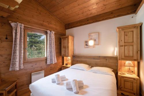 ein Schlafzimmer in einem Blockhaus mit einem Bett und einem Fenster in der Unterkunft Résidence Clos des Etoiles in Chamonix-Mont-Blanc