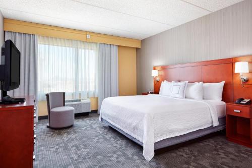 a hotel room with a bed and a flat screen tv at Courtyard Phoenix North / Happy Valley in Phoenix