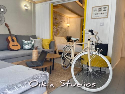 OIKIASTUDIOS2 في باترا: دراجة متوقفة في غرفة المعيشة مع أريكة