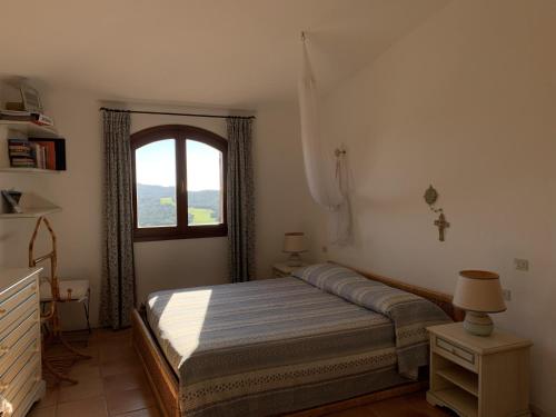 a bedroom with a bed and a window at Costa Smeralda appartamento Pevero Golf in Arzachena