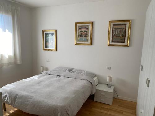 een slaapkamer met een bed en twee foto's aan de muur bij Appartamento Borgo Secolo in Peschiera del Garda