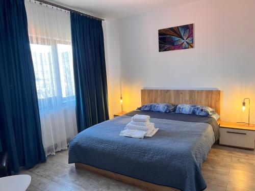 een slaapkamer met een bed met handdoeken erop bij Agropensiunea Vila Cristina in Niculiţel
