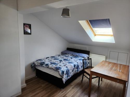 a bedroom with a bed and a wooden table at Jey's Flat in Liverpool