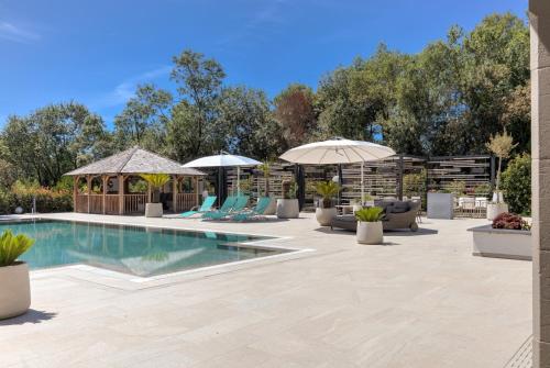 a swimming pool with chairs and umbrellas at Luxury Zen in Châteauneuf