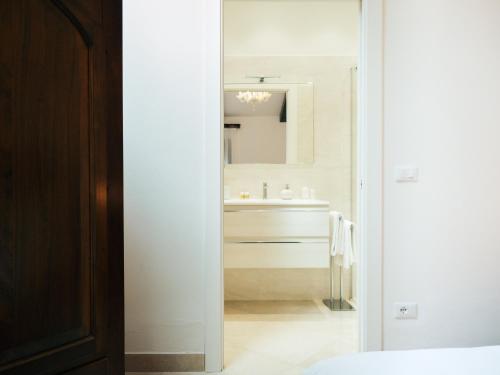 a white bathroom with a sink and a mirror at Ca' Mazzega in Murano