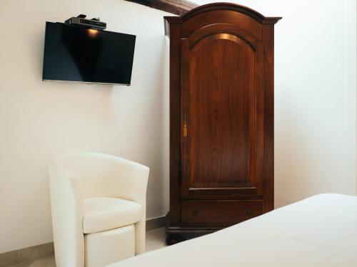 a bedroom with a bed and a tv and a chair at Ca' Mazzega in Murano