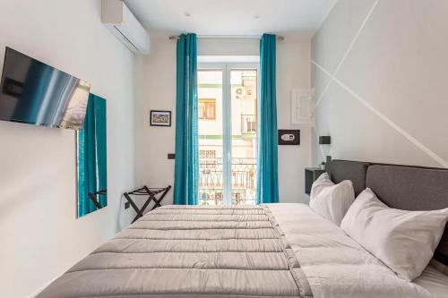 1 dormitorio con 1 cama con cortinas azules y ventana en Palermo Central en Palermo